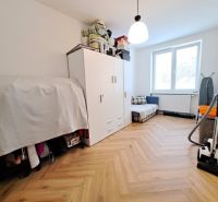 Ein Zimmer in einer 3-Zimmer-Wohnung mit einem Boden in Holzoptik, einem Schrank und einem Staubsauger.