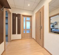 Der Flur in der 3-Zimmer-Wohnung mit einem Boden in Holzoptik und Wandhaken.