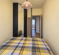 Schlafzimmer mit Einbauschrank und kariertem Überwurf in einer 3-Zimmer-Wohnung.