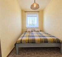 Schlafzimmer mit Bett und gemustertem Teppich in einer 3-Zimmer-Wohnung.