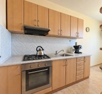 Küchenzeile mit Holzdekor in einer 3-Zimmer-Wohnung, ausgestattet mit einem Herd und einer Kaffeemaschine.