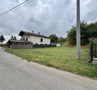 Baugrundstück in Medzianky, neben der Straße, mit nahegelegenen bewaldeten Gebieten.