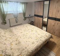 Schlafzimmer in einem Einfamilienhaus mit Holzboden, Einbauschrank und Bett.