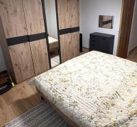 Ein Schlafzimmer mit Bett, Schrank und Holzboden in einem Einfamilienhaus.