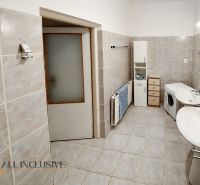 Badezimmer in einer 2-Zimmer-Wohnung mit Waschmaschine, Doppelwaschbecken und cremefarbenen Fliesen.