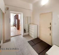 Flur mit weißen Möbeln, Spiegel und Eingang zum Zimmer in einer 2-Zimmer-Wohnung.