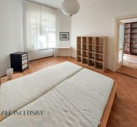 Schlafzimmer mit Einbauregal, Schreibtisch und Boden in Holzoptik in einer 2-Zimmer-Wohnung.