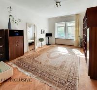 Wohnzimmer in einer 2-Zimmer-Wohnung mit Teppich und Bodenbelag in Holzoptik.