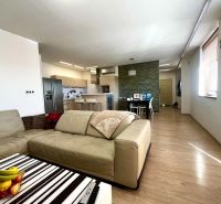 Wohnzimmer einer 3-Zimmer-Wohnung mit Holzboden und Küchenzeile.