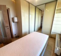 Schlafzimmer in einer 3-Zimmer-Wohnung mit Holzboden, Bett und Einbauschrank.