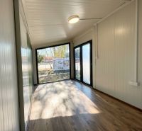 Innenraum mit verglasten Wänden und Boden in Holzoptik, Besondere Immobilien.