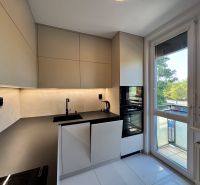 Küche in einer 3-Zimmer-Wohnung mit moderner Küchenzeile, eingebauten Geräten und großem Fenster.