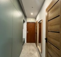 Flur in einer 3-Zimmer-Wohnung mit Holzboden und Holztüren.