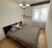 Schlafzimmer mit Doppelbett und Holzboden in einer 3-Zimmer-Wohnung.