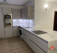 Küche in einer 3-Zimmer-Wohnung mit Marmor-Arbeitsplatte und Boden in Holzoptik.
