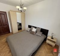 Schlafzimmer in einer 3-Zimmer-Wohnung mit einem Doppelbett und einem Schrank, Boden mit Holzdekor.