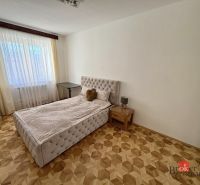 Schlafzimmer mit Bett, Nachttisch und Boden in Holzoptik, 3-Zimmer-Wohnung.