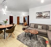 Wohnzimmer in einer 3-Zimmer-Wohnung mit einem bequemen Sofa und einem dekorativen Bild an der Wand.