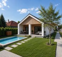 Ein Garten bei einem Einfamilienhaus mit Pool in der Straße in Veľká Mača unter blauem Himmel.