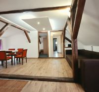 Ferienwohnung mit Holzboden, Holzbalken und bequemen Möbeln.