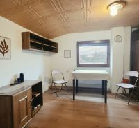 Innenraum einer Ferienwohnung mit Holzmöbeldekor und Klappstühlen.