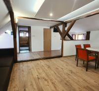 Eine Ferienwohnung mit Holzbalken und einem Boden in Holzoptik bietet einen Essbereich.