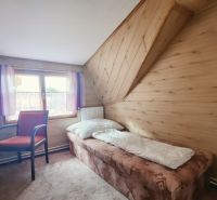 Einzelzimmer im Ferienapartment mit Holzboden und Fenster.