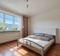 Schlafzimmer im Einfamilienhaus mit Bett und Boden in Holzoptik.