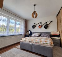 Schlafzimmer in einem Einfamilienhaus mit Gitarren an der Wand, Boden mit Holzdekor.