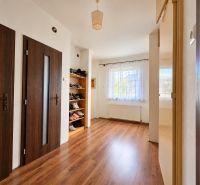 Innenraum eines Einfamilienhauses mit Holzboden, Türen und einem Schuhregal.