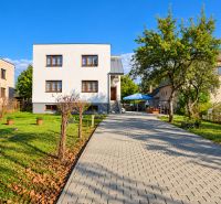 Ein Einfamilienhaus in Martin mit Zufahrtsstraße und Garten, umgeben von Grünflächen und Bäumen.