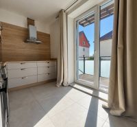 Küche in einer 2-Zimmer-Wohnung mit Fliesenboden und großen Fenstern.
