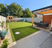 Ein gepflegter Garten eines Einfamilienhauses am Schwarzen Wasser, Schwarzes Wasser, mit Terrasse und Rasen.