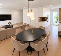Innenraum eines Einfamilienhauses mit Möbeln, hellen Wänden und einem Boden in Holzoptik.