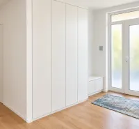 Eingangsbereich in einem Einfamilienhaus mit Holzboden und Einbauschrank.