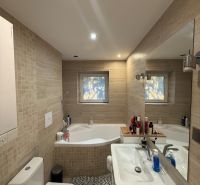 Badezimmer in einer 2-Zimmer-Wohnung mit Badewanne, Waschbecken und Waschmaschine, gefliest.