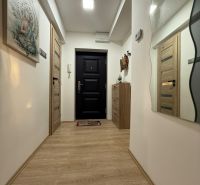 Der Flur in einer 2-Zimmer-Wohnung mit einem Boden in Holzoptik, Dekorationen und einem Spiegel.