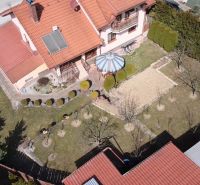 Ein Einfamilienhaus in Stará Ľubovňa mit Garten, Rasen, Pavillon und Solarpaneelen auf dem Dach.
