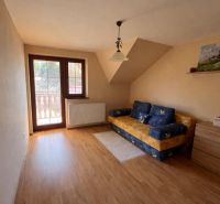 Ein Zimmerinterieur in einem Einfamilienhaus mit Holzboden und einem Sofa.