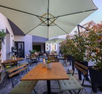 Eine eingerichtete Terrasse von Gastronomiebetrieben in Bratislava - Altstadt mit Sitzgelegenheiten und Sonnenschirmen.