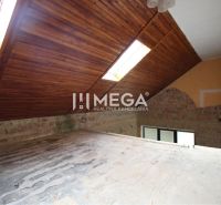 Das Dachgeschoss eines Einfamilienhauses mit Holz-Dachfenstern, Ziegelwand, Lichtschächte im Dach.