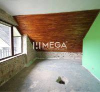Ein Zimmer in einem Einfamilienhaus mit Holzbalkendecke und freiliegenden Ziegeln.