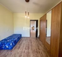 Ein Zimmer in einer 2-Zimmer-Wohnung mit einem Boden in Holzoptik und Möbeln.