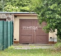 Garagen in der Osloboditeľov-Straße in Humenné mit einem Holztor, umgeben von Grün.