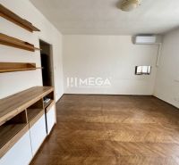 Ein Zimmer in einer 3-Zimmer-Wohnung mit einem Holzboden und Wandregalen.