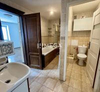 Badezimmer in einer 3-Zimmer-Wohnung mit Fliesen und weißer Sanitärkeramik.