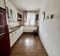 Küche in einer 3-Zimmer-Wohnung mit Holzboden, weißen Möbeln, rotem Kühlschrank.