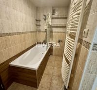 Badezimmer mit Fliesen, Badewanne und Handtuchheizkörper in einer 3-Zimmer-Wohnung.