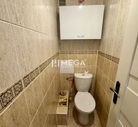 Toilette mit Fliesen und weißen Möbeln in einer 3-Zimmer-Wohnung.