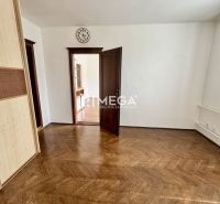 Ein Raum in einer 3-Zimmer-Wohnung mit einem Boden in Holzoptik und offenen Türen.